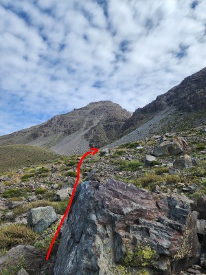 Camino al Canalón Foto: 6Se sigue caminando por un terreno con abundantes rocas en dirección Noroeste hacia la entrada de la quebrada que se ve al final de la línea roja en la foto.Benjamin Villaleiva